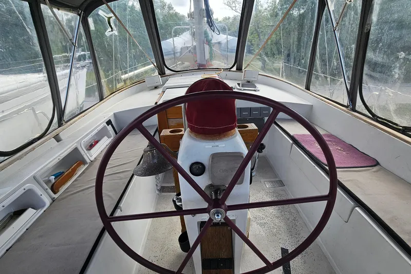 Slide: The Image of Interior view of a 1982 Morgan 462 sailboat cockpit with steering wheel and navigation equipment. - 25