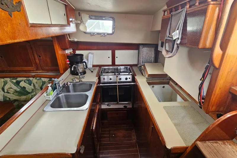 Slide: The Image of 1982 Morgan 462 yacht kitchen with stove, sink, and wooden cabinetry. - 31