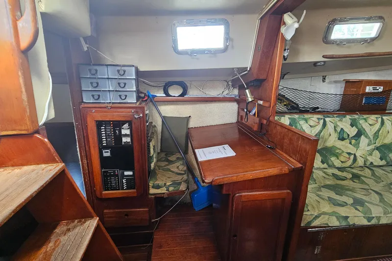 Slide: The Image of 1982 Morgan 462 yacht interior with wooden cabinetry, navigation station, and tropical-patterned seating. - 33
