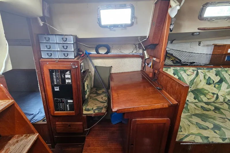Slide: The Image of Interior of a 1982 Morgan 462 sailboat featuring a wooden navigation desk and storage area. - 35
