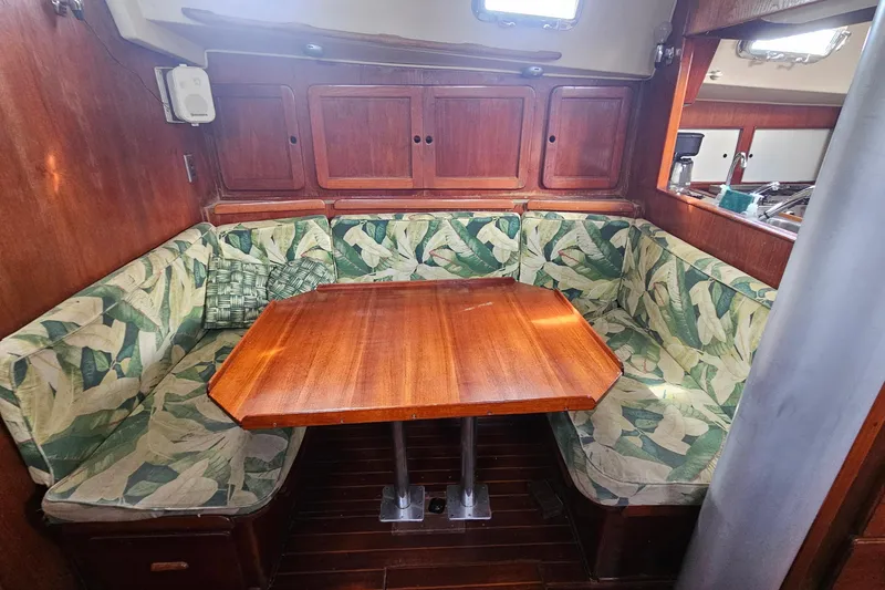 Slide: The Image of Cozy dining area in a 1982 Morgan 462 yacht with wooden table and leaf-patterned cushions. - 38