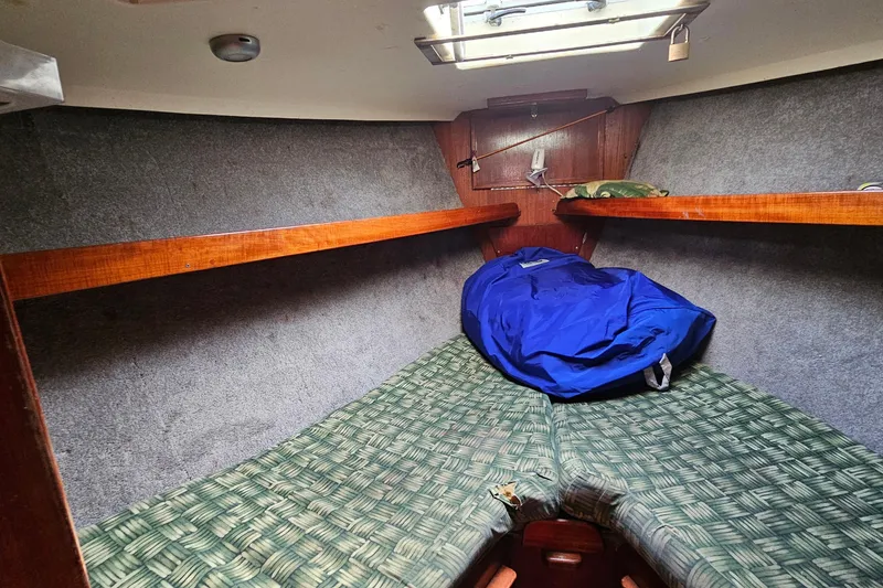 Slide: The Image of Cozy cabin interior of 1982 Morgan 462 sailboat with sleeping bag and wooden shelves. - 42