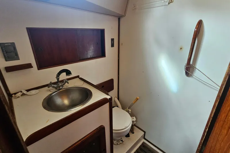 Slide: The Image of 1982 Morgan 462 yacht bathroom with sink and toilet, featuring wooden accents and compact design. - 45