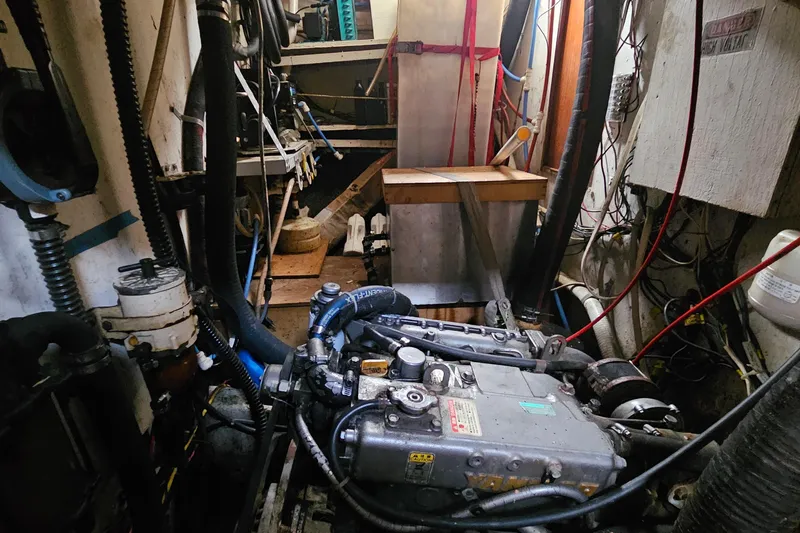 Slide: The Image of Engine room of a 1982 Morgan 462 sailboat, showcasing mechanical components and wiring. - 50
