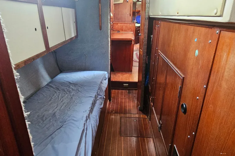 Slide: The Image of Interior of a 1982 Morgan 462 sailboat with wooden paneling and a cozy berth. - 54
