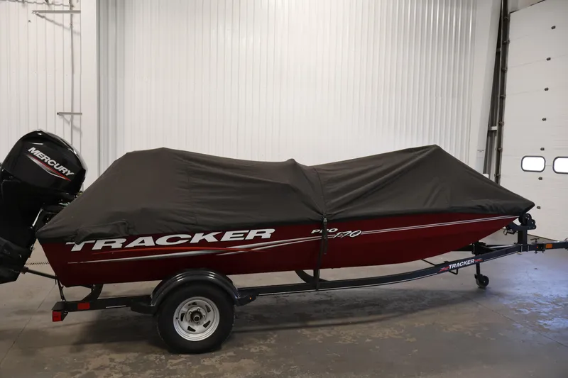 Slide: The Image of 2022 Tracker Pro 170 boat with cover and Mercury outboard motor in a garage. - 38