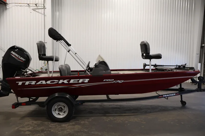 Slide: The Image of 2022 Tracker Pro 170 fishing boat with Mercury engine in a garage setting. - 4