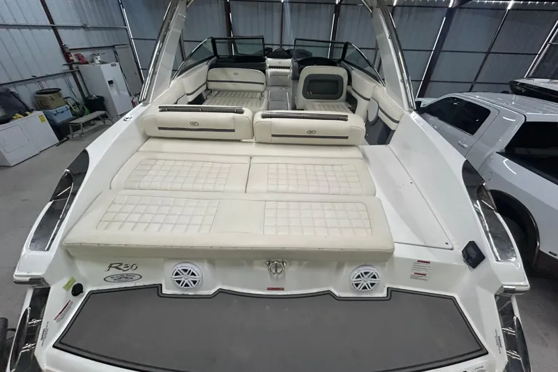 Slide: The Image of 2017 Cobalt R30 boat interior with white cushioned seating in a garage setting. - 21