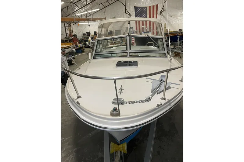 Slide: The Image of 1993 Limestone Express boat in a warehouse, featuring a sleek white hull and American flag. - 2