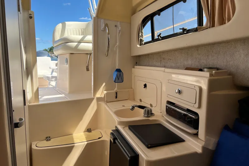 Slide: The Image of Interior of 2005 Grady-White Islander 270 boat, featuring compact kitchen area. - 10