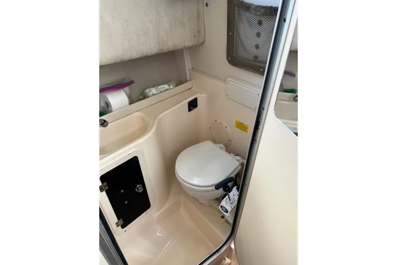 Slide: The Image of 2005 Grady-White Islander 270 boat bathroom interior with toilet and storage. - 12