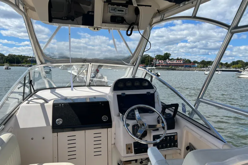 Slide: The Image of 2005 Grady-White Islander 270 boat interior with steering wheel, docked on a sunny day. - 3