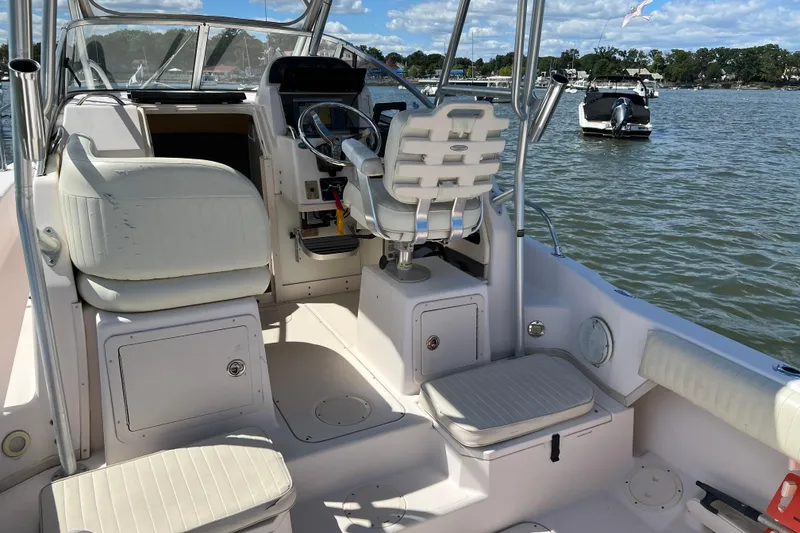 Slide: The Image of 2005 Grady-White Islander 270 boat interior with seating and steering wheel on a sunny day. - 4