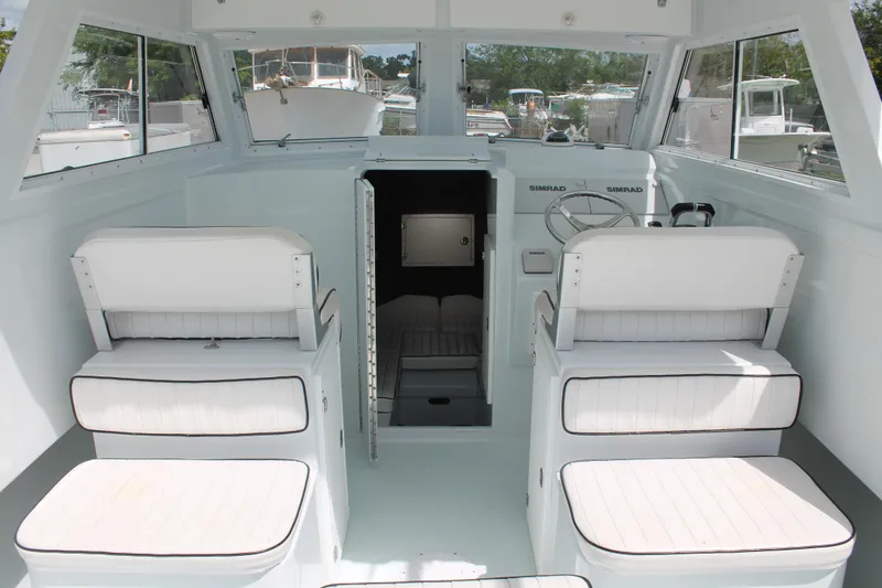 Slide: The Image of Interior of 2015 Stamas Americana 26 boat with white seating and steering console. - 11