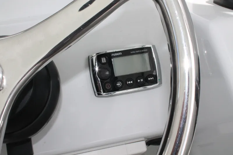 Slide: The Image of Steering wheel and Fusion MS-NRX200i on 2015 Stamas Americana 26 boat dashboard. - 15