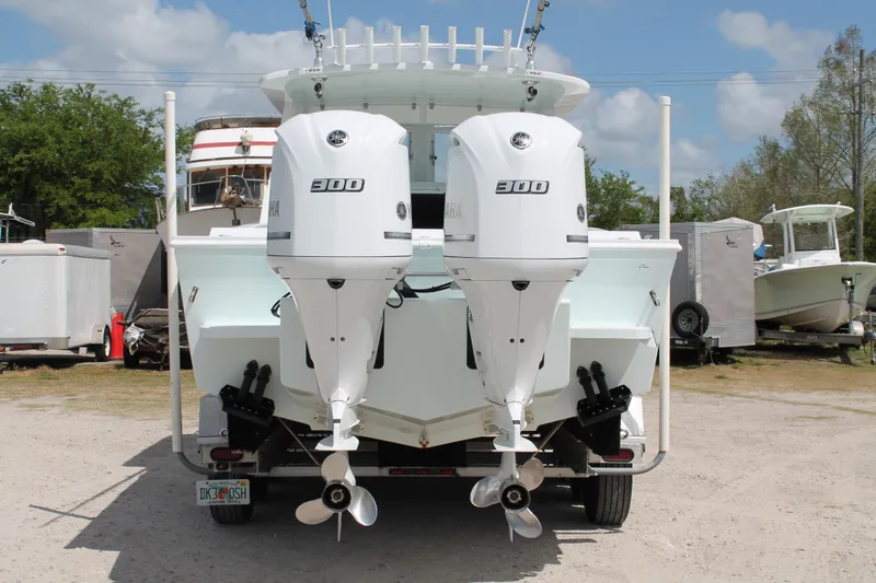 Slide: The Image of 2015 Stamas Americana 26 boat with dual Yamaha 300 engines, parked outdoors. - 5