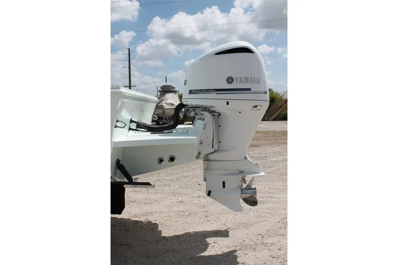 Slide: The Image of Yamaha outboard motor on 2015 Stamas Americana 26 boat, parked on sandy terrain. - 7