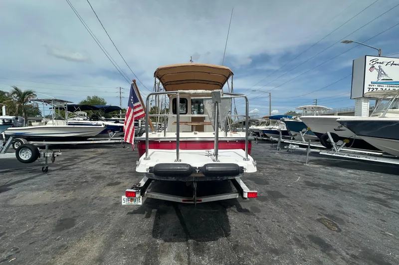 Slide: The Image of 2015 Ranger Tugs R-21 EC boat displayed at a dealership with American flag. - 3