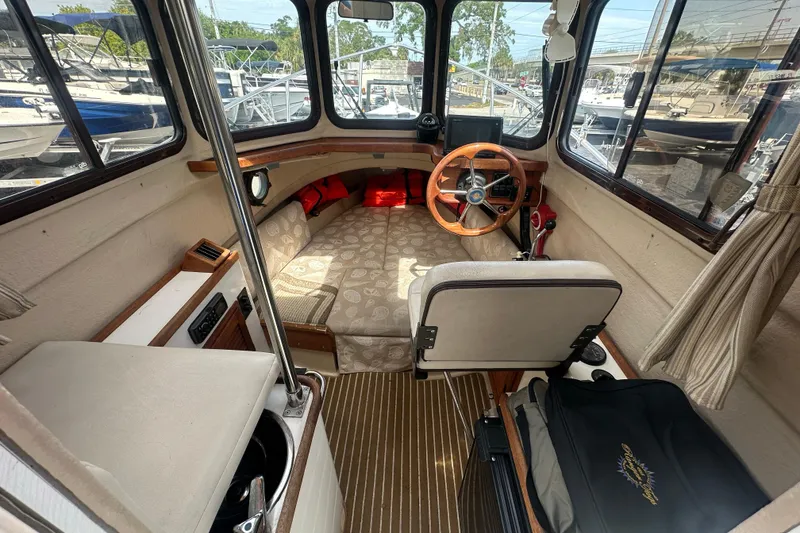 Slide: The Image of 2015 Ranger Tugs R-21 EC boat interior with helm, seating, and windows. - 6