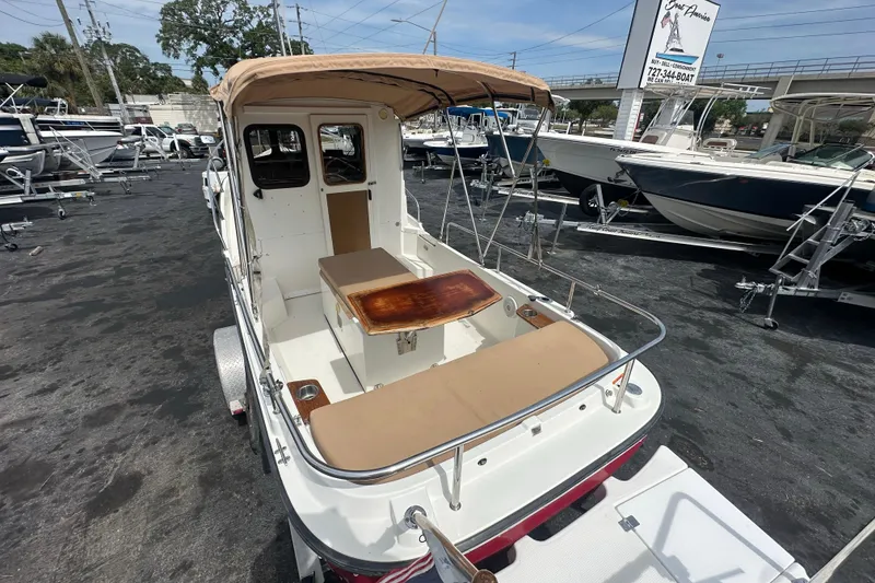 Slide: The Image of 2015 Ranger Tugs R-21 EC boat with canopy, docked in a marina. - 8
