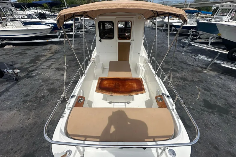 Slide: The Image of 2015 Ranger Tugs R-21 EC boat with canopy, docked among other vessels. - 9