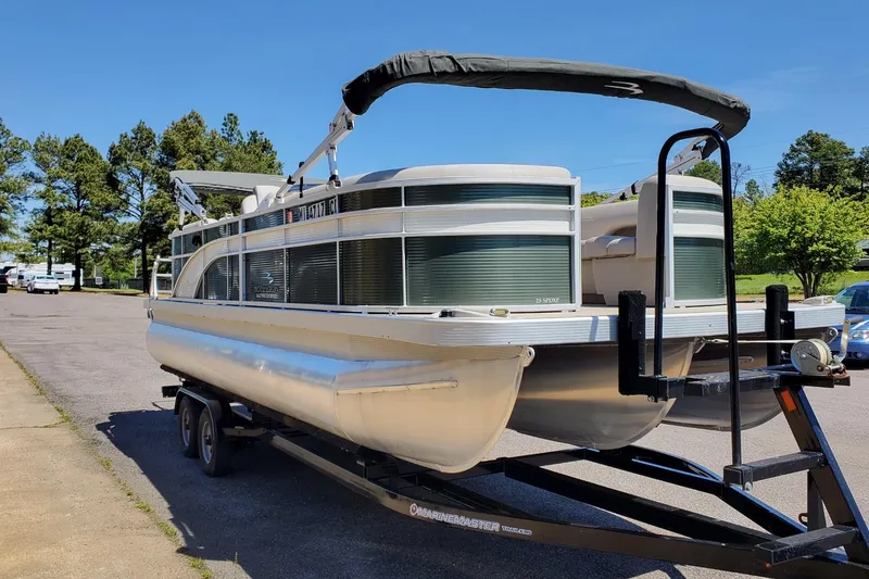 The Image of 2019 Bennington SX 23 SPDXP pontoon boat on trailer, parked outdoors. - 0