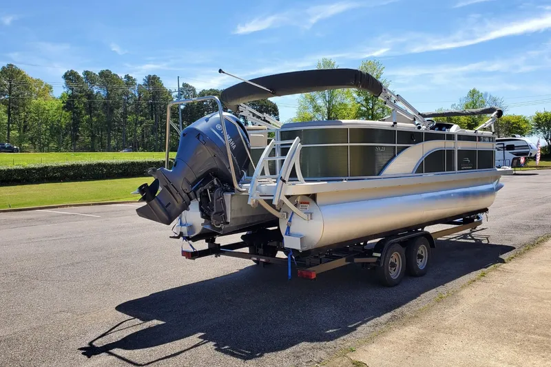 Slide: The Image of 2019 Bennington SX 23 SPDXP pontoon boat on trailer, parked outdoors. - 2