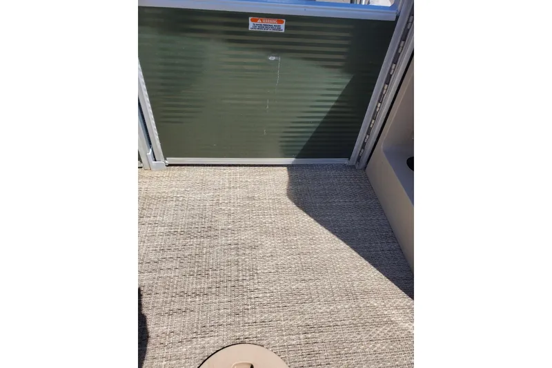 Slide: The Image of 2019 Bennington SX 23 SPDXP boat interior with textured flooring and metal gate. - 8