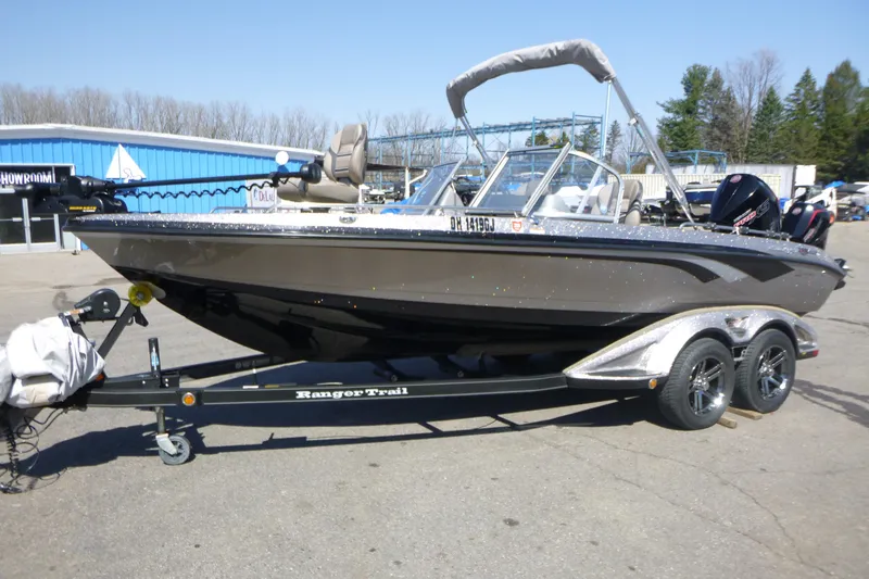 Slide: The Image of 2019 Ranger 620FS Fisherman boat on trailer, parked outdoors near a blue building. - 4