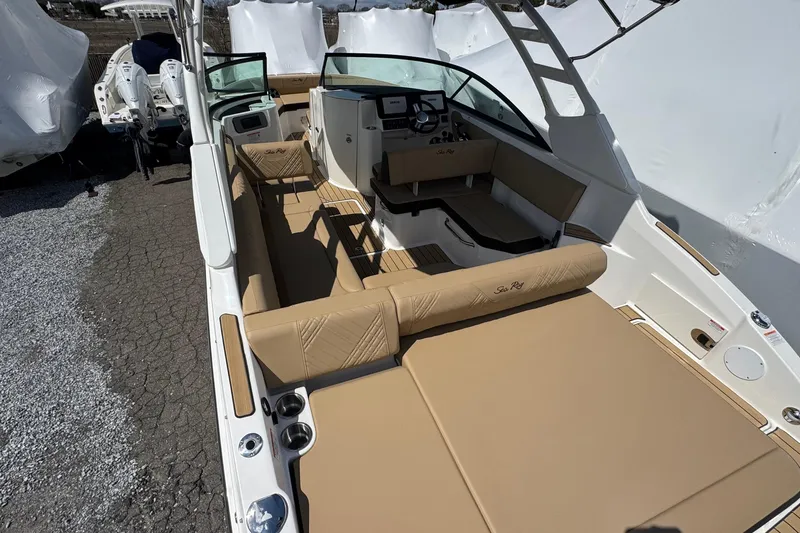 Slide: The Image of 2026 Sea Ray SDX 250 Outboard boat interior with tan seating and modern dashboard. - 10