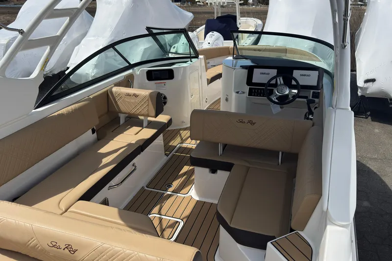 Slide: The Image of 2026 Sea Ray SDX 250 Outboard boat interior with tan seating and modern dashboard. - 18