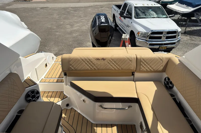 Slide: The Image of 2026 Sea Ray SDX 250 Outboard boat interior with tan seating and wood accents. - 19