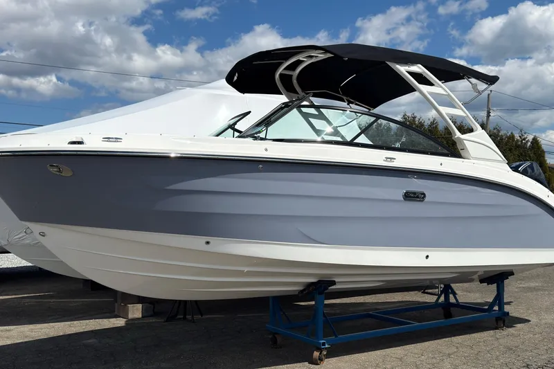 Slide: The Image of 2026 Sea Ray SDX 250 Outboard boat on display under a clear blue sky. - 2