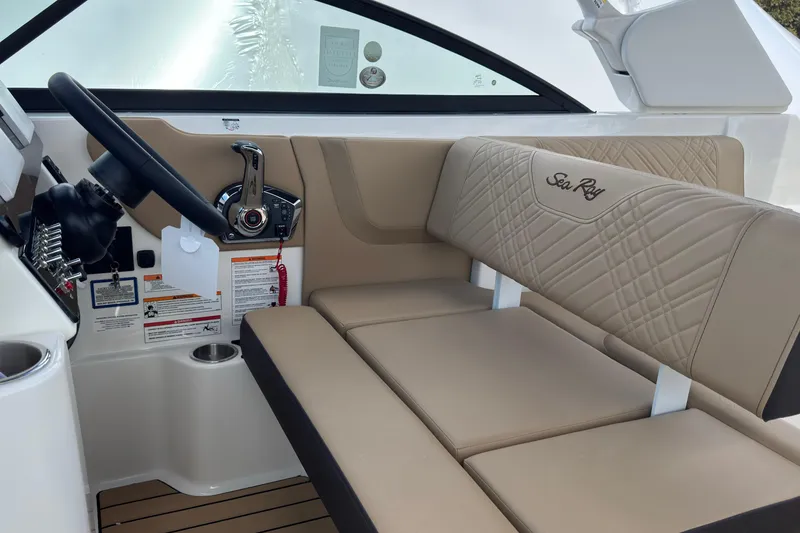 Slide: The Image of Interior of 2026 Sea Ray SDX 250 Outboard, featuring beige seating and modern controls. - 26