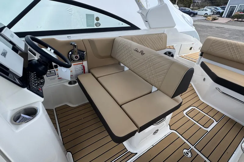 Slide: The Image of 2026 Sea Ray SDX 250 Outboard interior with beige seating and modern helm controls. - 27