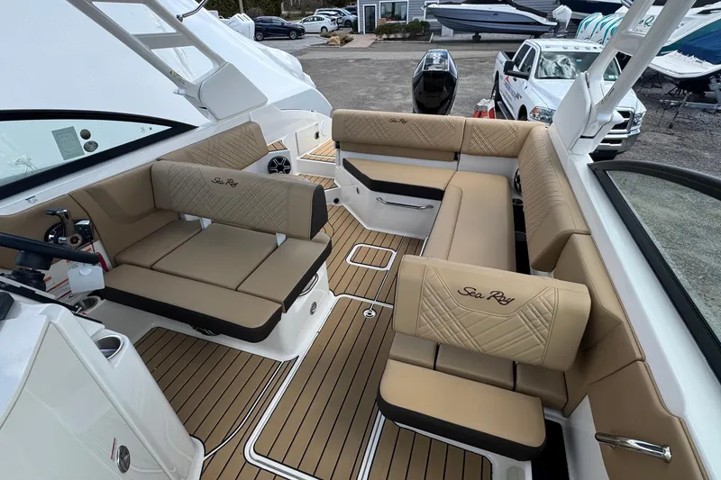 Slide: The Image of 2026 Sea Ray SDX 250 Outboard boat interior with luxurious tan seating and wood flooring. - 32