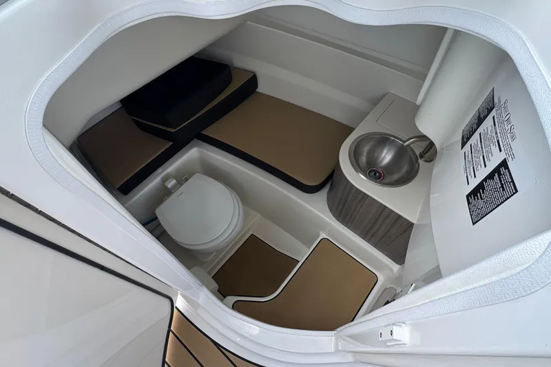 Slide: The Image of Interior of 2026 Sea Ray SDX 250 Outboard boat bathroom with toilet and sink. - 35