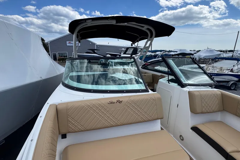 Slide: The Image of 2026 Sea Ray SDX 250 Outboard boat with tan seating and sleek design under a blue sky. - 43