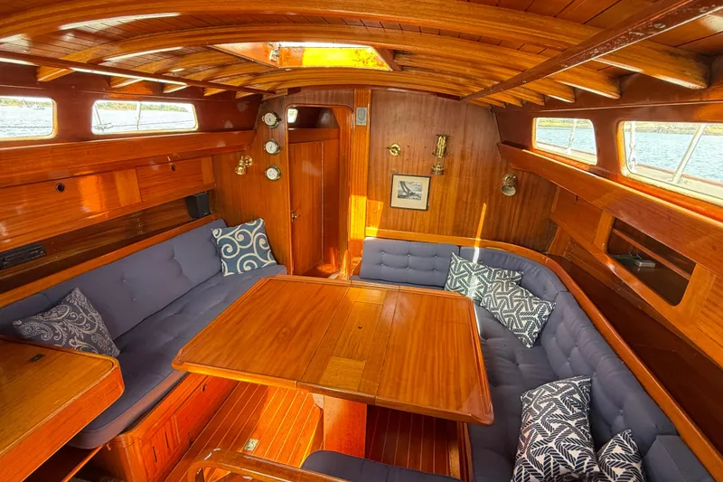 Slide: The Image of Cozy interior of a 1986 Vindo 45 sailboat with wooden finish and cushioned seating. - 10