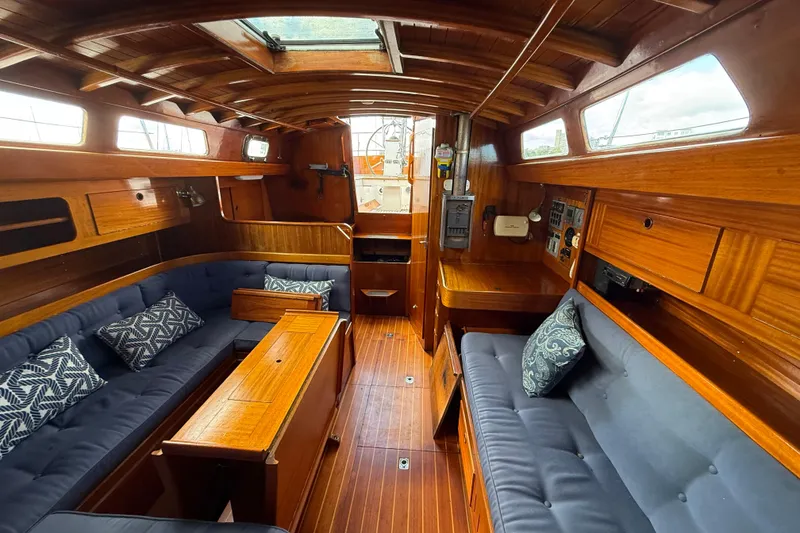 Slide: The Image of Interior of a 1986 Vindo 45 sailboat with wooden finish and blue seating. - 11