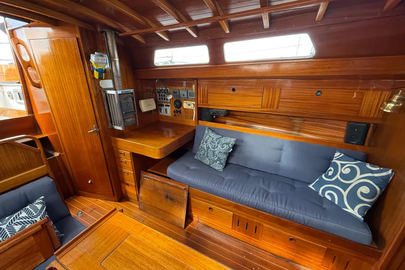 Slide: The Image of Cozy interior of 1986 Vindo 45 sailboat with wooden finish and cushioned seating. - 13