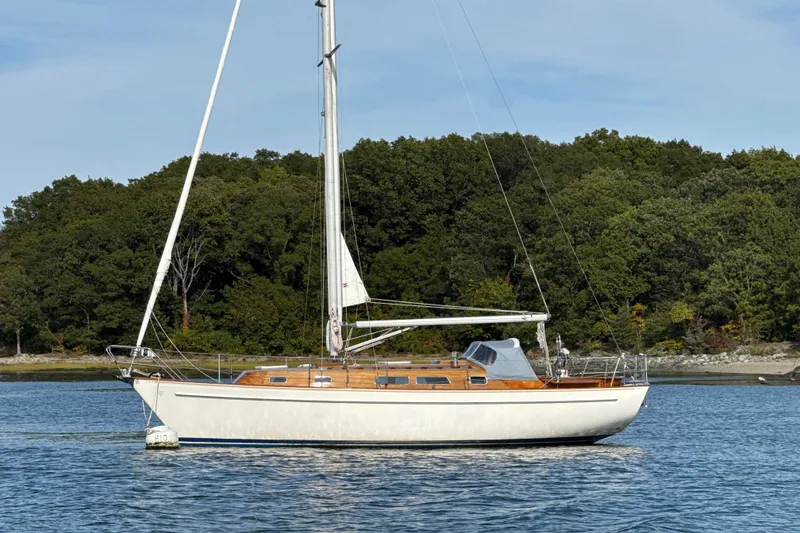 Slide: The Image of Sailboat Vindo 45, 1986 model, anchored on calm water with forested shoreline. - 3