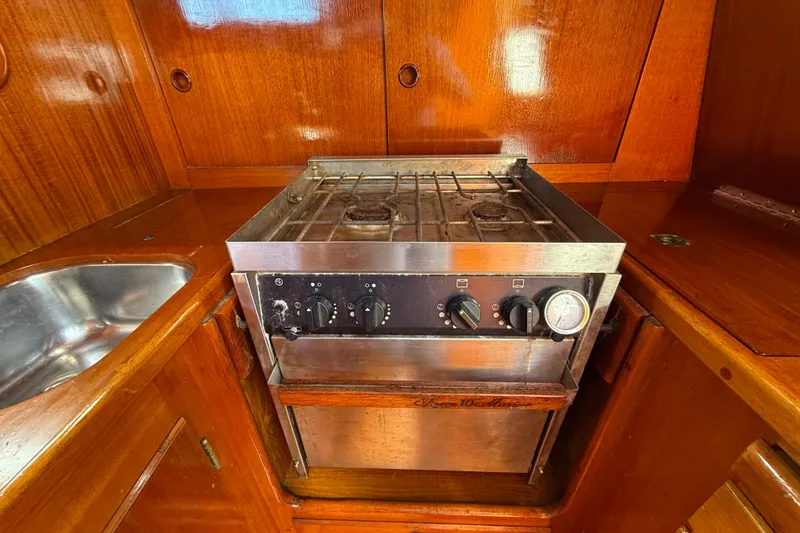 Slide: The Image of Vintage 1986 Vindo 45 yacht kitchen with stainless steel stove and wooden cabinetry. - 30