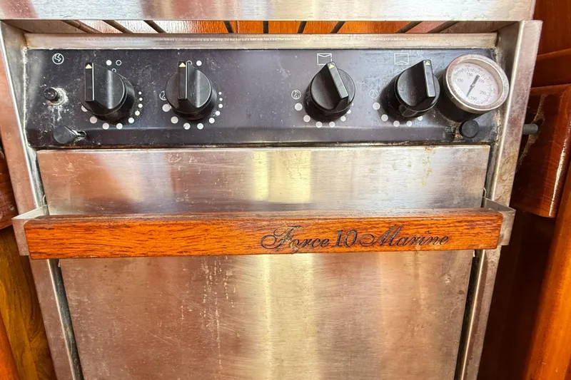 Slide: The Image of Force 10 Marine stove with control knobs and temperature gauge on a Vindo 45, 1986 model. - 32