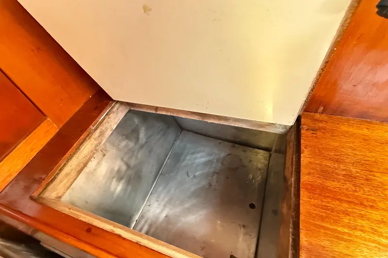 Slide: The Image of Open storage compartment in 1986 Vindo 45 boat interior with wooden finish. - 33