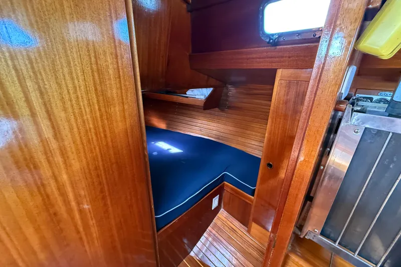 Slide: The Image of Cozy wooden cabin interior of 1986 Vindo 45 sailboat with blue cushioned seating. - 34