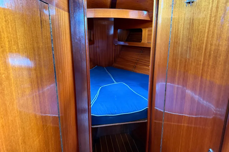 Slide: The Image of Interior cabin of a 1986 Vindo 45 sailboat with wooden finish and blue bedding. - 36