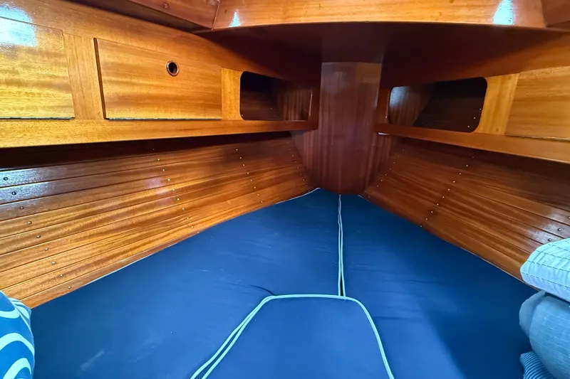 Slide: The Image of Interior cabin of a 1986 Vindo 45 sailboat with polished wood and blue cushions. - 38