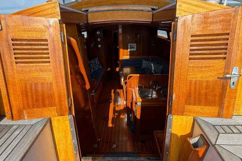 Slide: The Image of Interior view of 1986 Vindo 45 sailboat with wooden finish and compact kitchenette. - 52