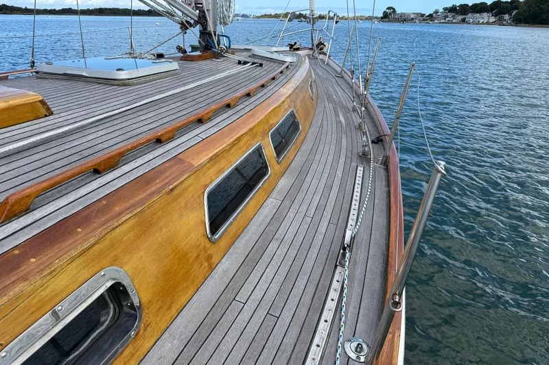 Slide: The Image of Wooden deck of 1986 Vindo 45 sailboat on calm water. - 54